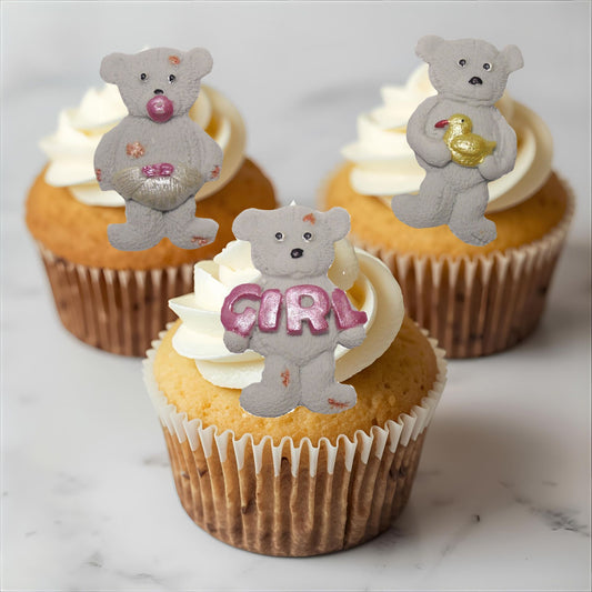 Cupcakes with grey teddy bear toppers on a marble surface