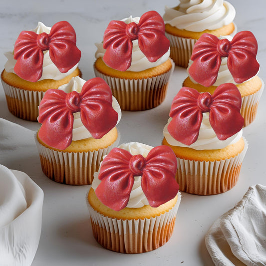 Cupcakes with red glittered edible bow decorations on a light background