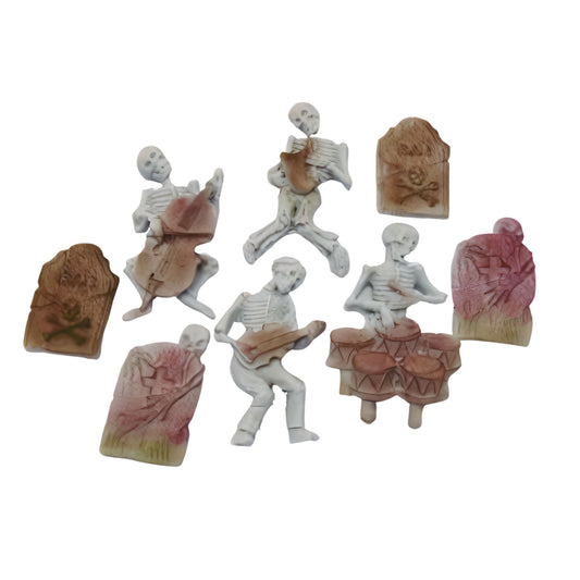 Set of miniature skeletons and tombstones cake decorations shown on a white background