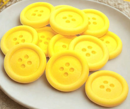 Yellow-colored shaped buttons on a white plate 