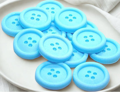Blue-colored shaped buttons on a white plate 