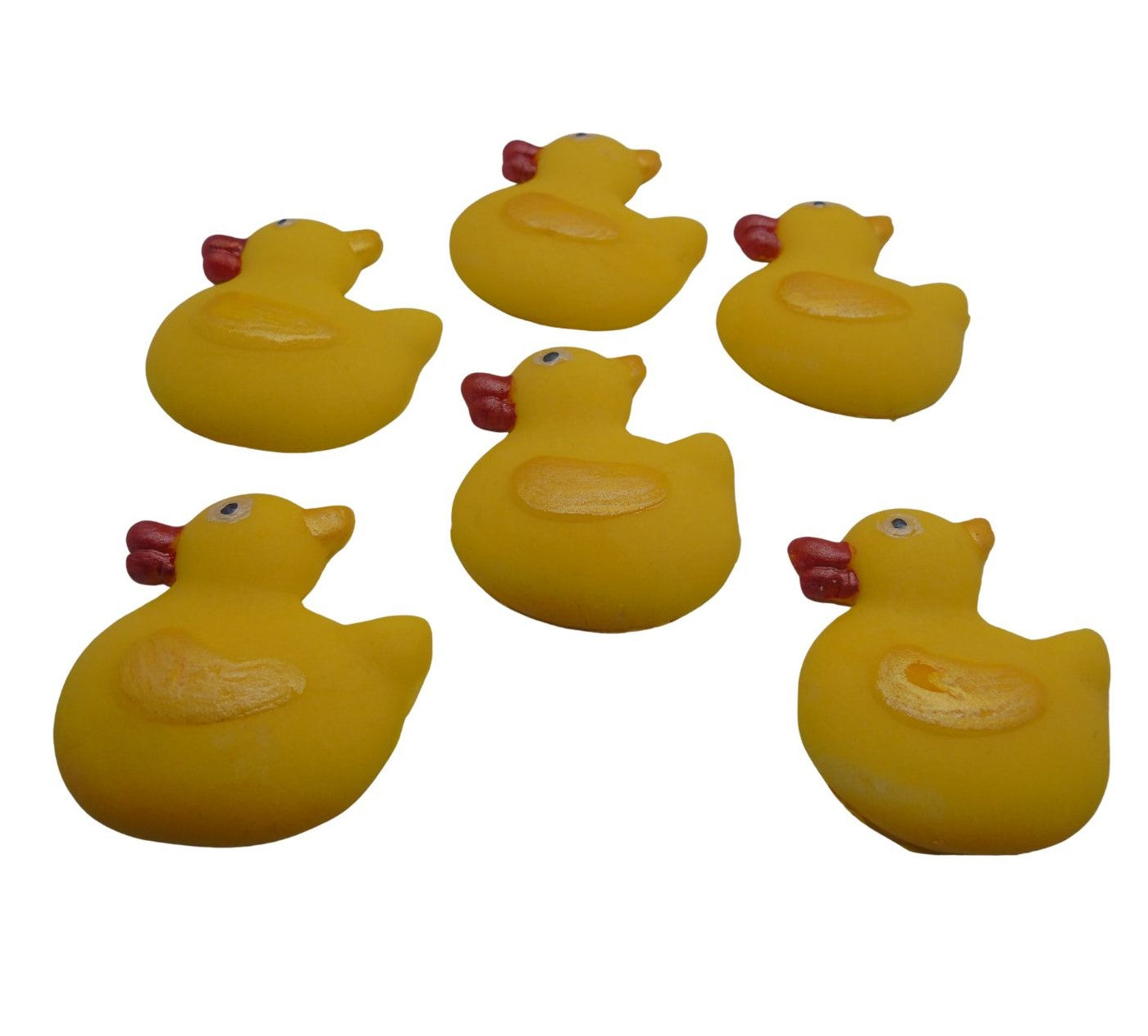 Set of six yellow sugar paste ducks with red beaks on a white background