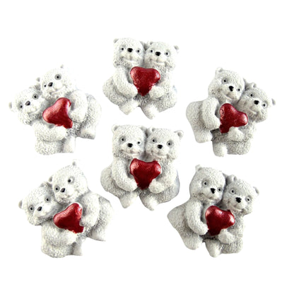 Set of six edible white  bear figurines holding red hearts on a white background