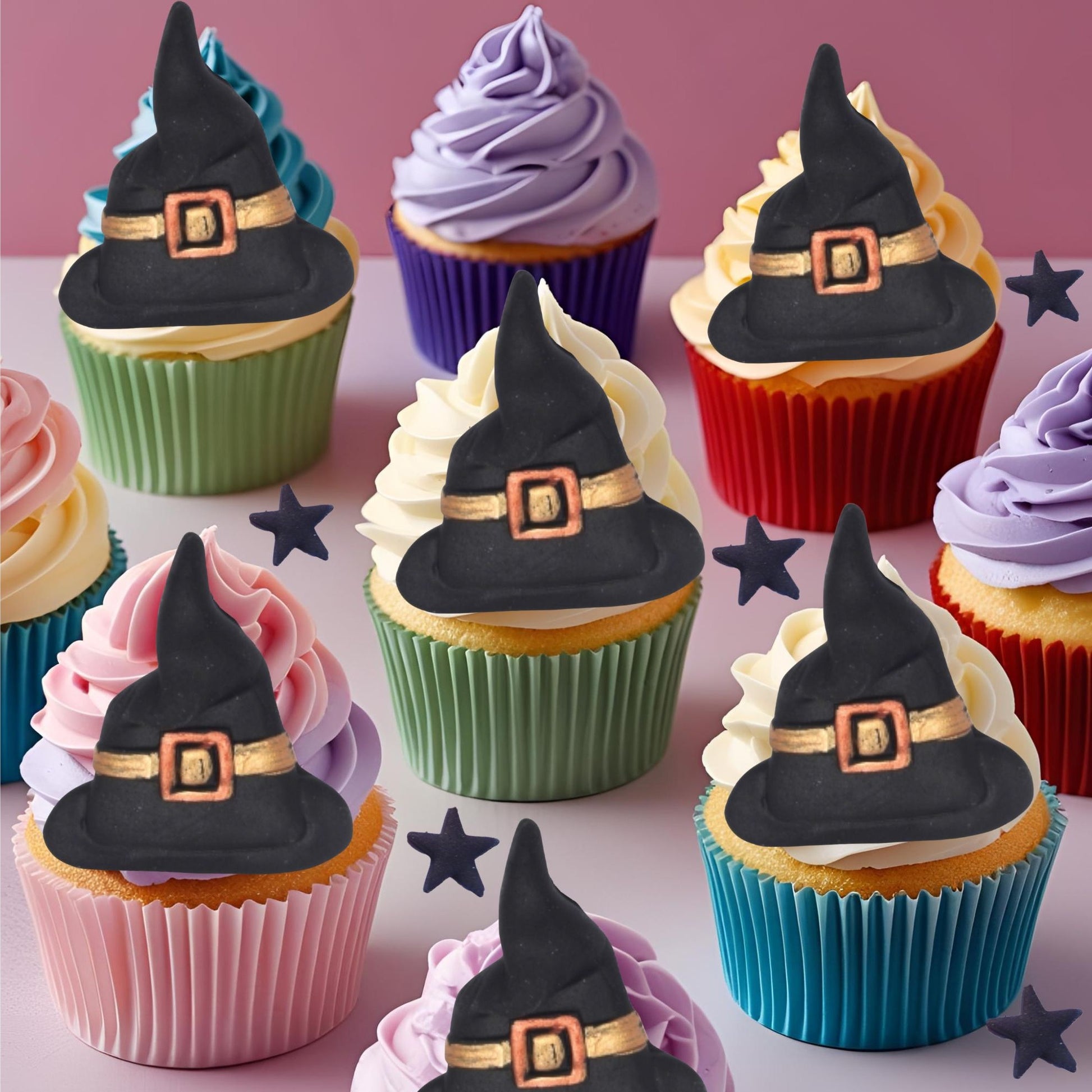 Cupcakes decorated with witch hats on a pink background