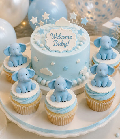 Baby shower cake and cupcakes with elephant decorations on a white stand.