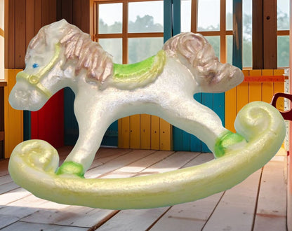White and green  rocking horse cake topper decorations shown with an background image in a playroom with wooden floor and colorful walls.