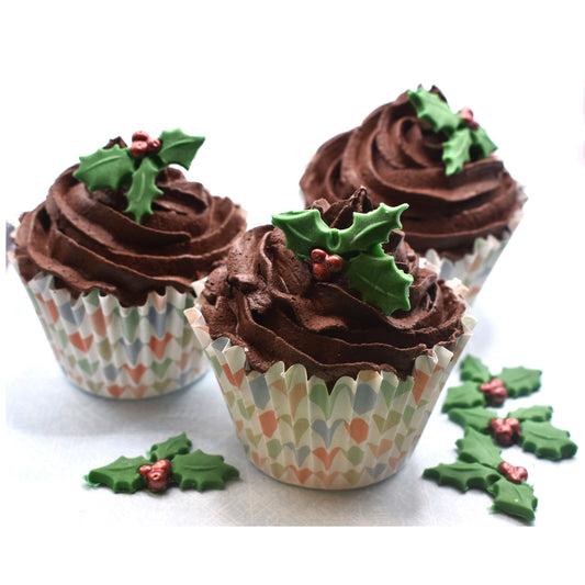 Chocolate cupcakes with edible  holly decorations on a white background
