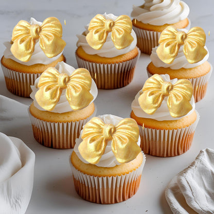 Cupcakes with gold glittered edible  bow decorations on a light background