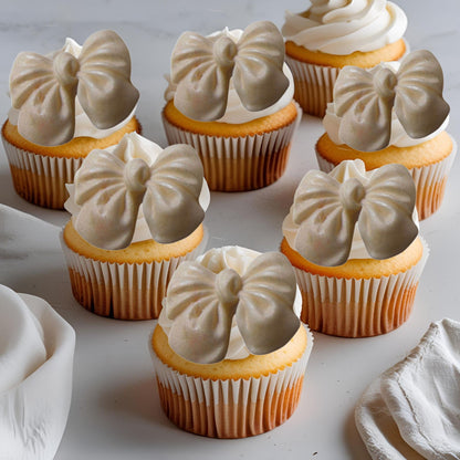 Cupcakes with ivory glittered edible  bow decorations on a light background