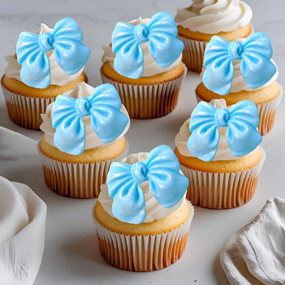 Cupcakes with blue glittered edible  bow decorations on a light background