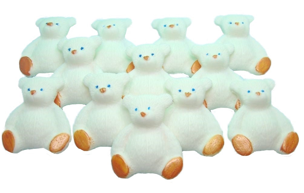 A set of white edible teddy bear cupcake toppers arranged in rows on a white background