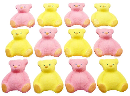 A set of  pink and yellow edible teddy bear cupcake toppers arranged in rows on a white background