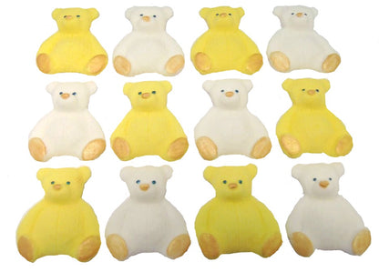 A set of yellow and white edible teddy bear cupcake toppers arranged in rows on a white background