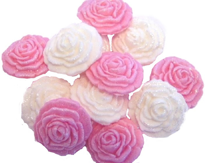 A collection of handmade edible glittered rose cupcake toppers in Pink and white