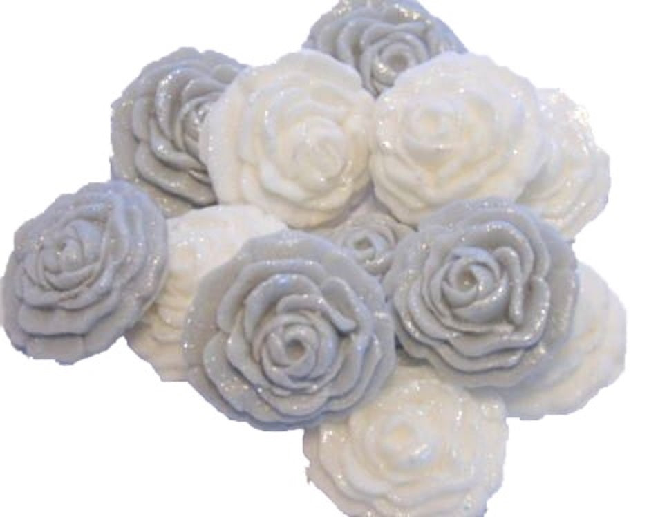 A collection of handmade edible glittered rose cupcake toppers in Silver and white