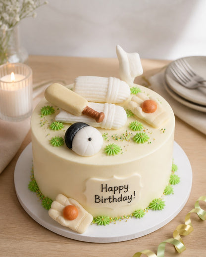 Small individual Birthday cake with cricket-themed decorations on a table with candles and plates.