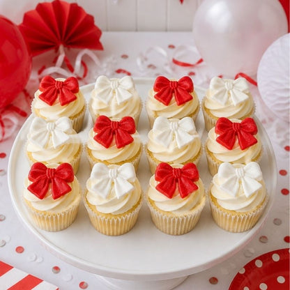 Decorative cupcakes with red and white bows on a white plate, festive background.