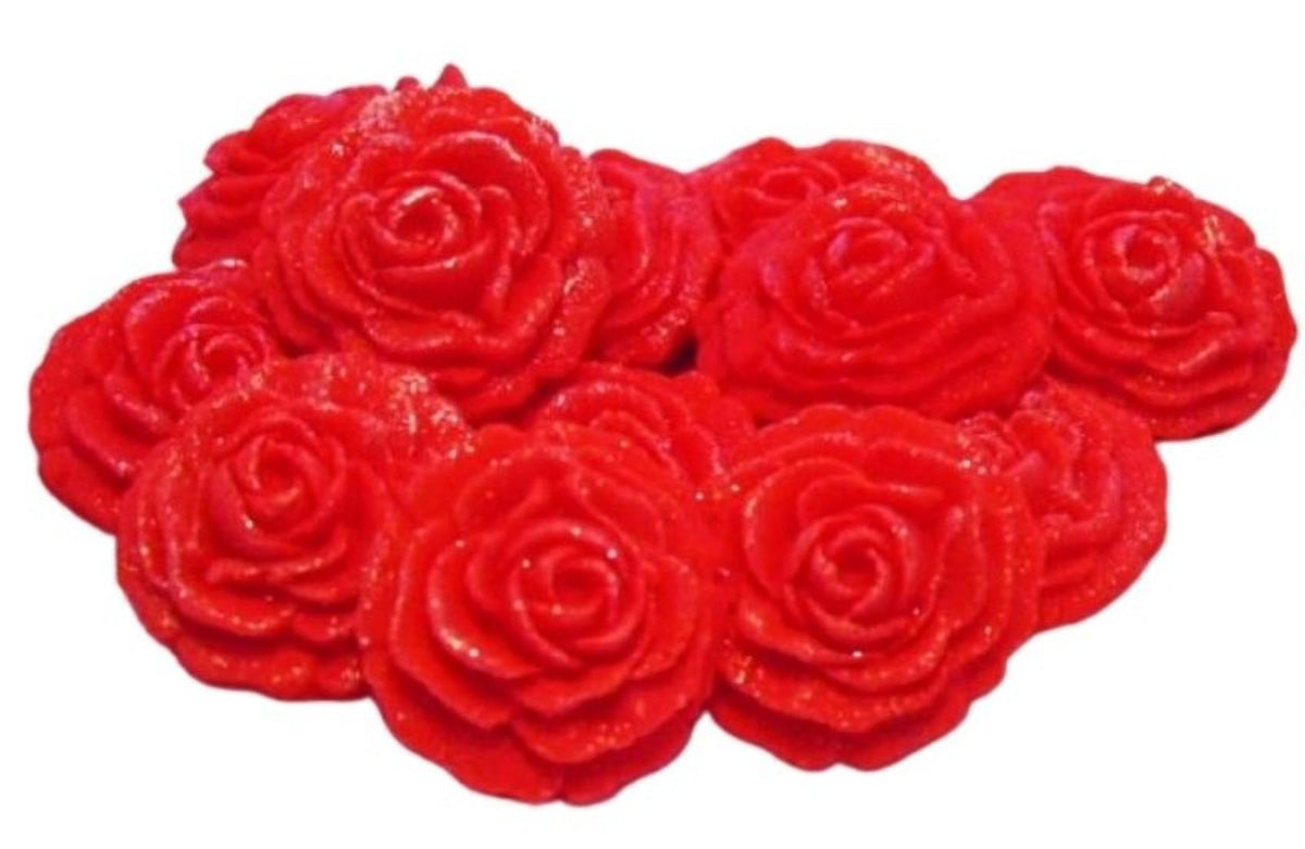 A cluster of red glittery rose-shaped embellishments or beads on a plain white background.