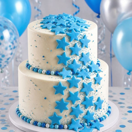 Blue stars cascading down the side of a two tiered cake with blue balloons in the background